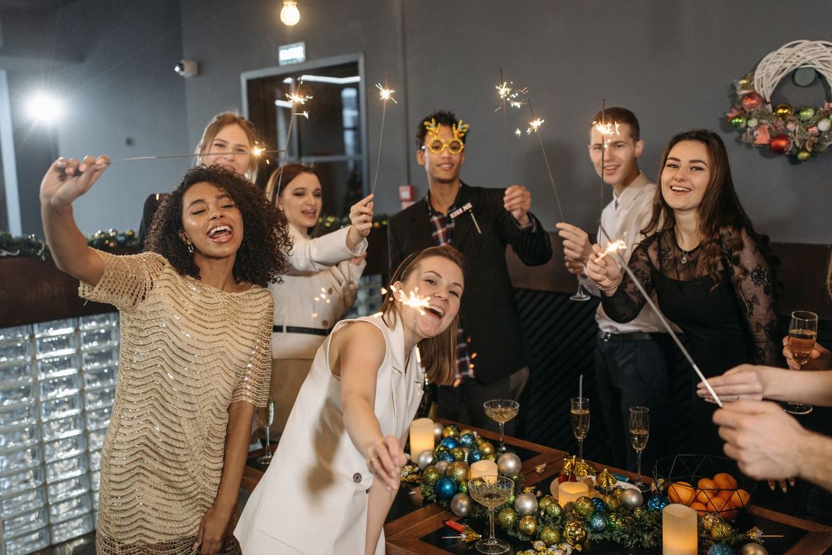 Colleagues laughing and holding sparklers at an office celebration