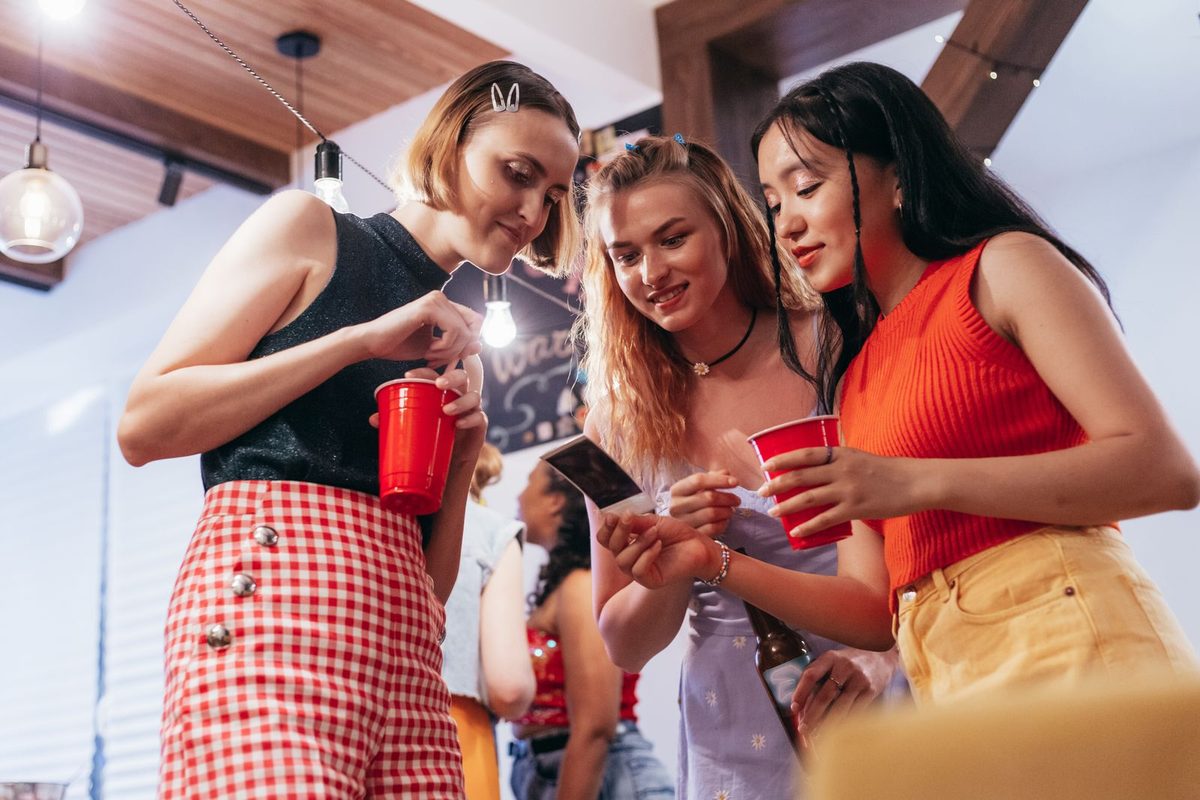 Friends laughing and looking at an instant photo at a party
